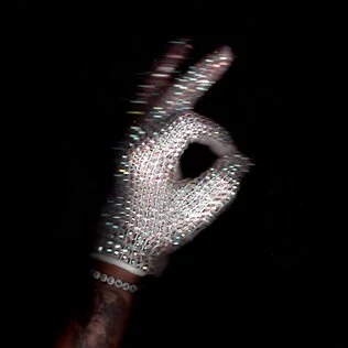 Pochette officielle de l'album Iceman de Drake, une main gantée de strass dans la pénombre
