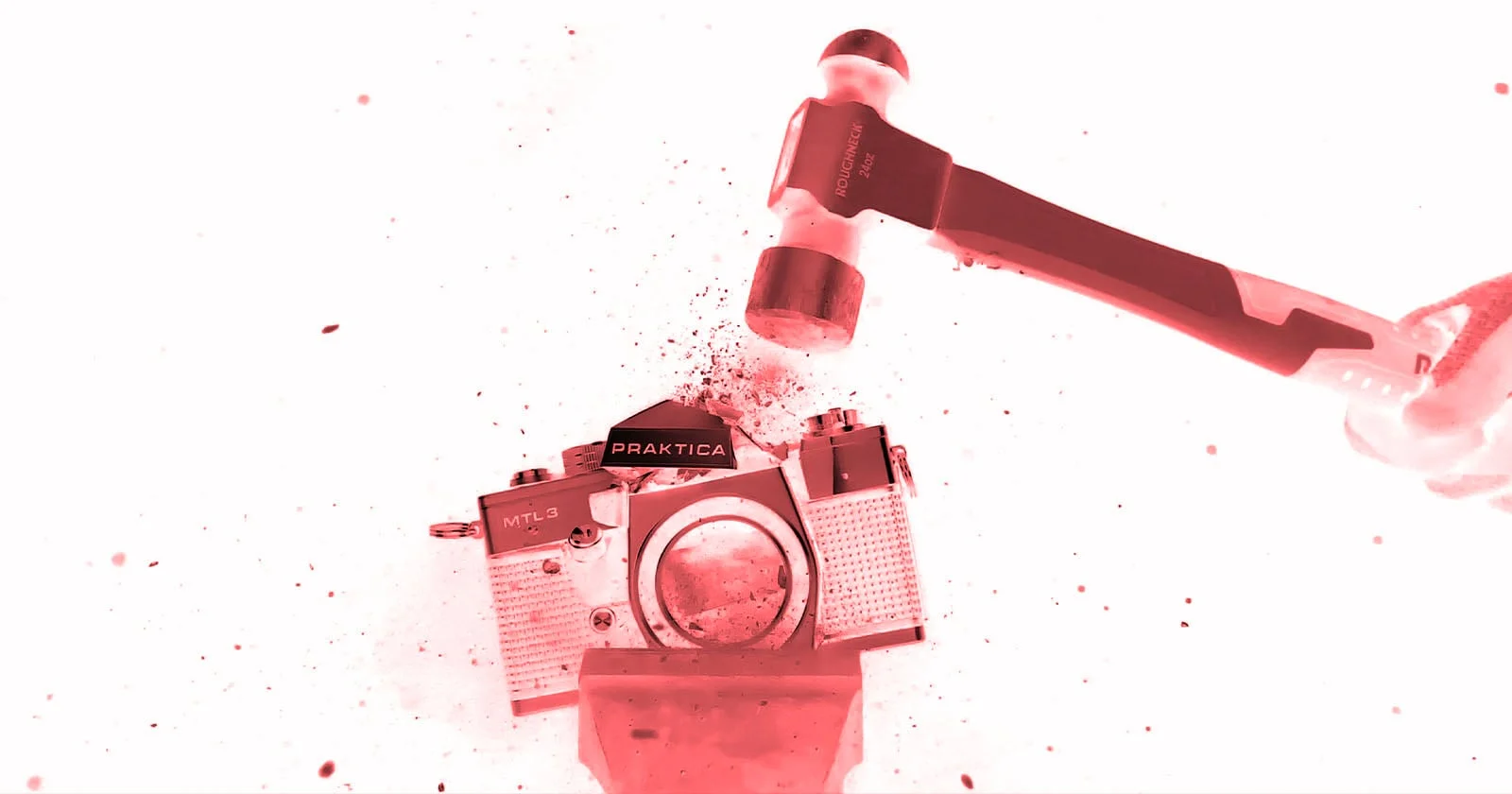 Un marteau s'abat sur un reflex argentique Praktica MTL3 lors de l'installation Camera Obsolete? du Belfast Photo Festival