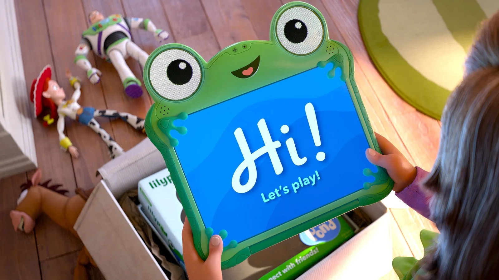Lilypad, la tablette-grenouille de Toy Story 5, tenue par une enfant pendant que Woody, Buzz et Jessie gisent au sol