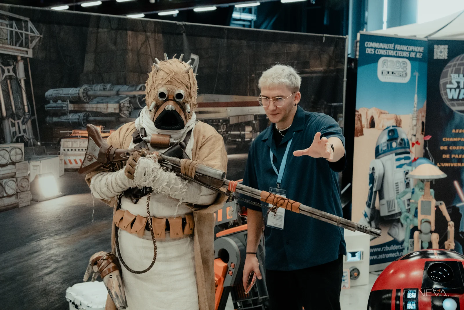 Neva aux côtés d'un cosplayer en Homme des Sables (Tusken) de Star Wars, devant le stand des R2 Builders francophones