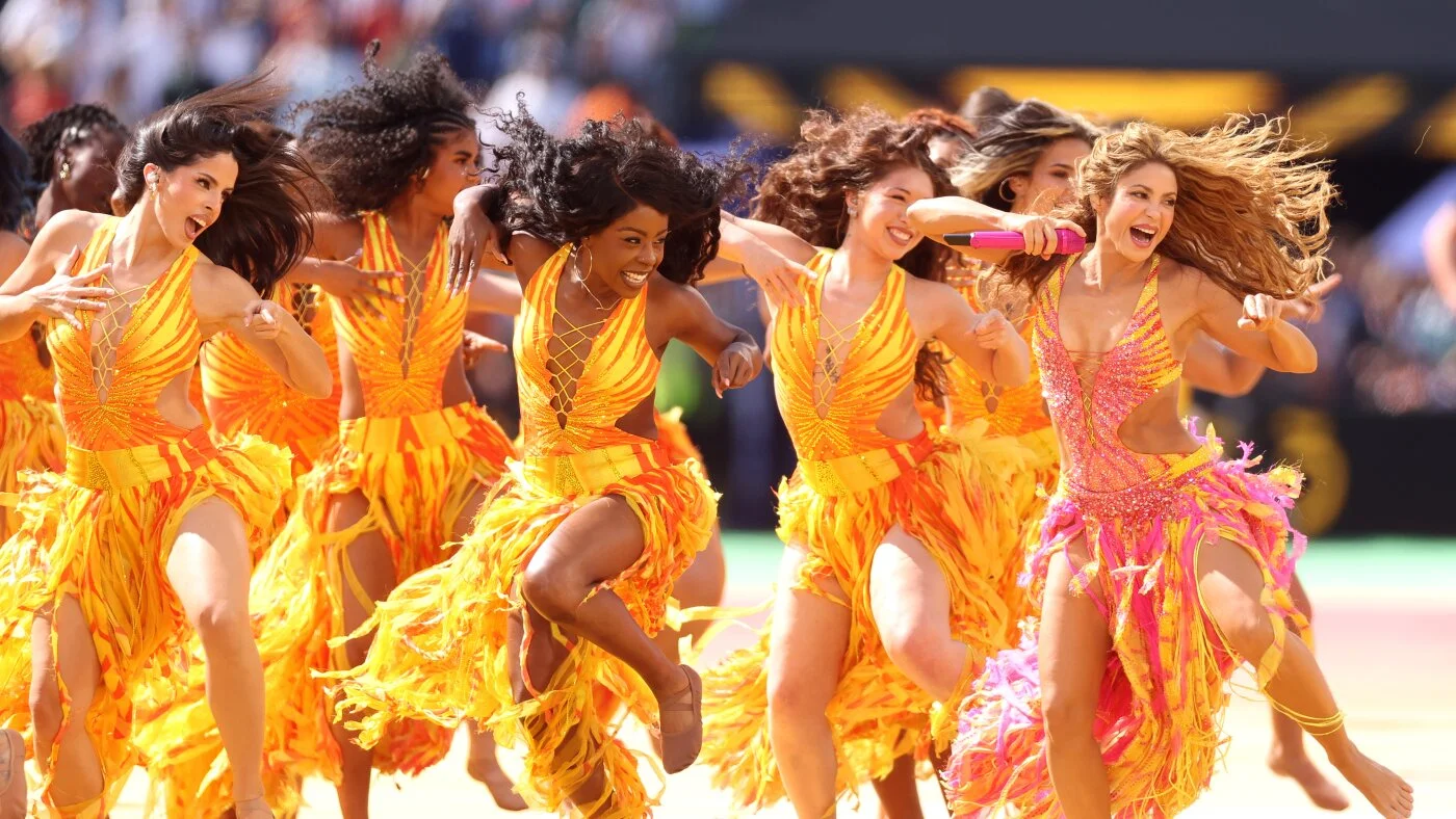 Shakira et ses danseuses en tenues orange et jaune pendant le show de mi-temps de la finale du Mondial 2026