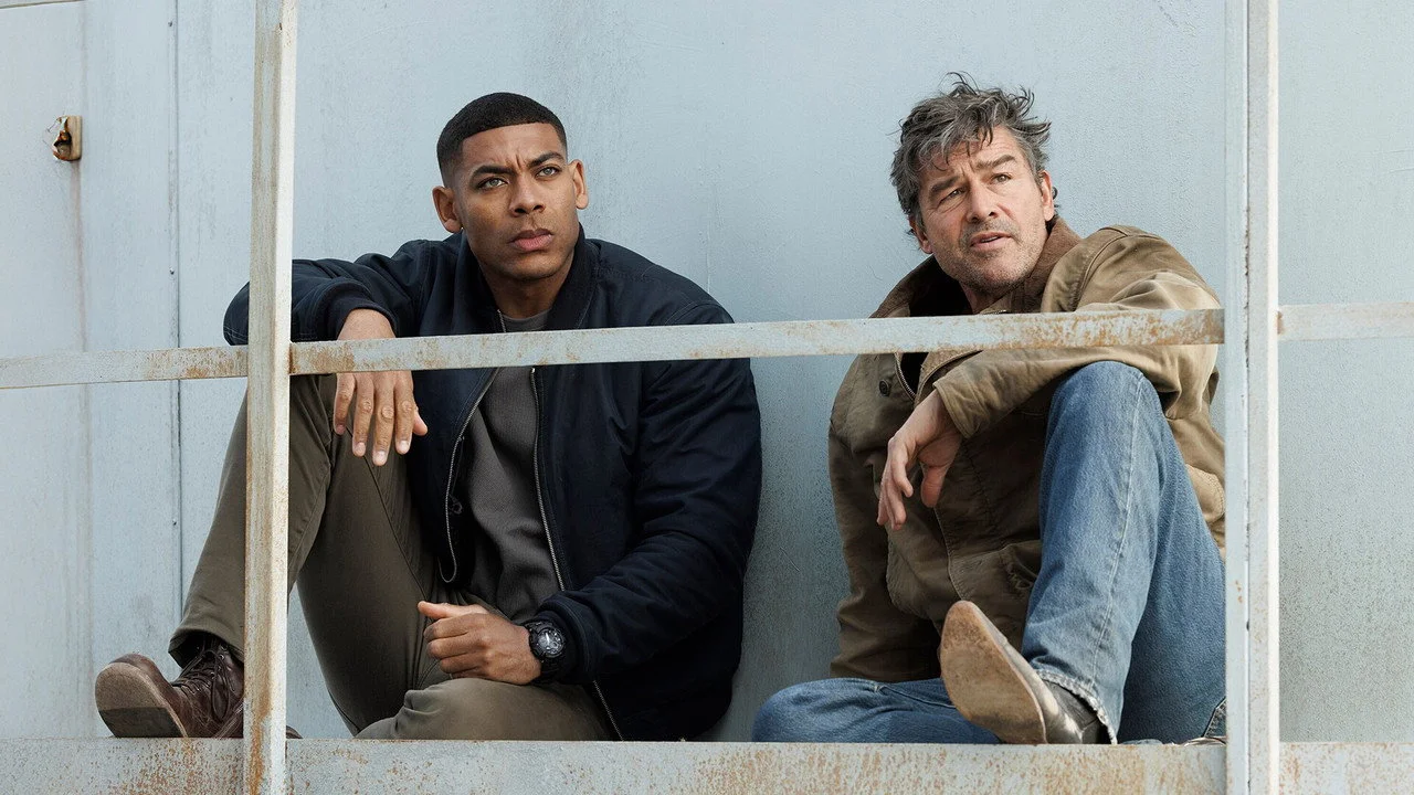 John Stewart (Aaron Pierre) et Hal Jordan (Kyle Chandler) assis dans les gradins du stade de Rushville